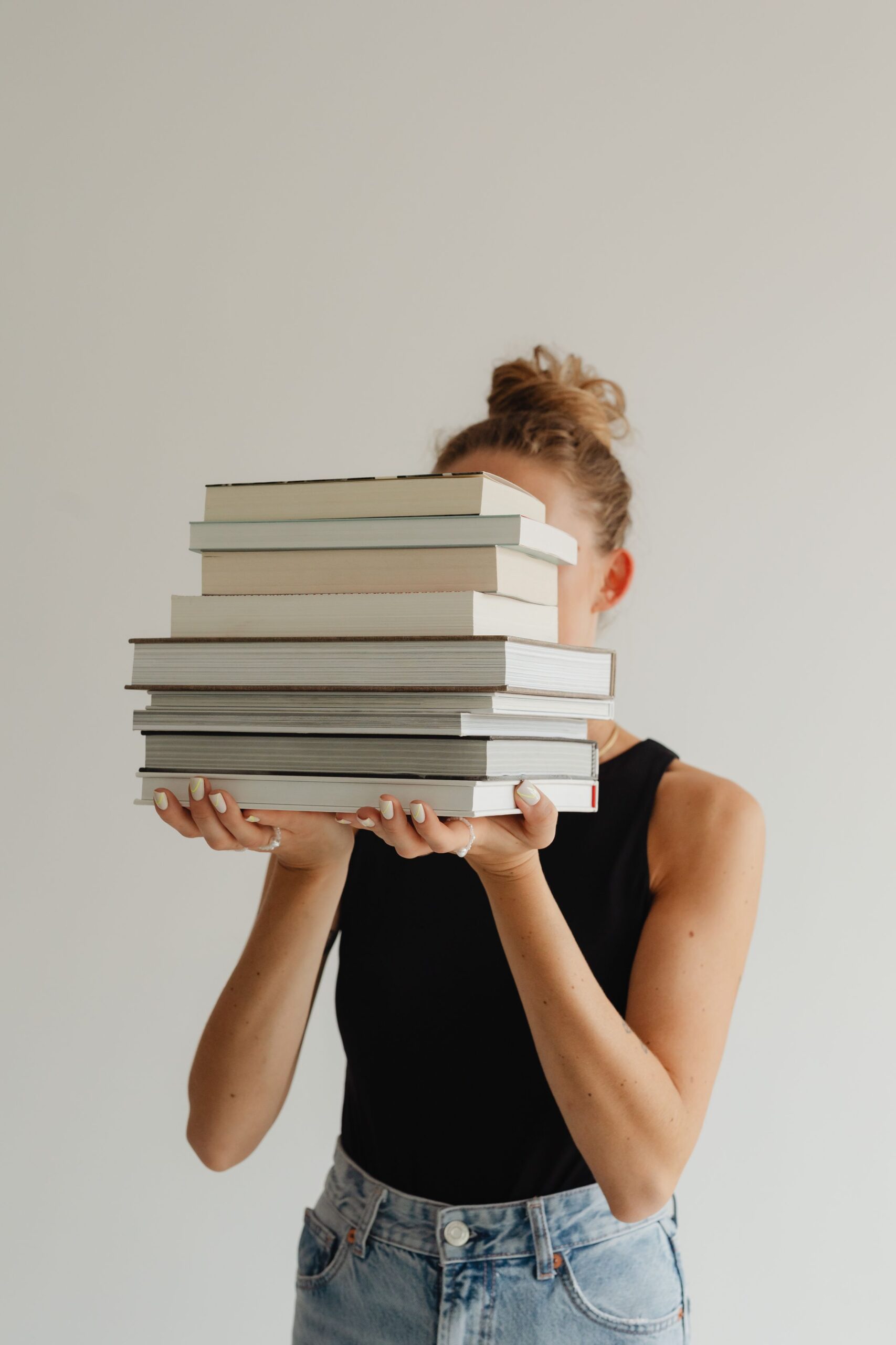 kaboompics_woman-in-light-colored-jeans-with-books-28222